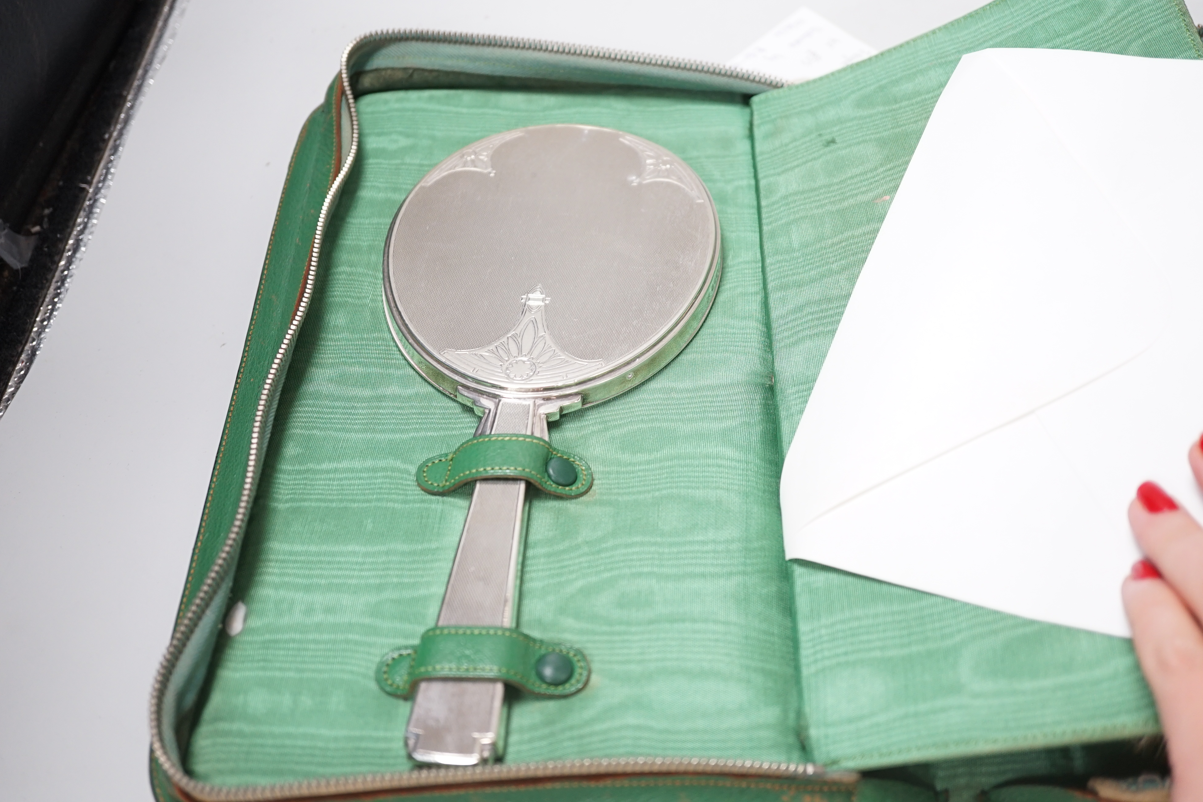A cased George V five piece silver mounted mirror, brush and comb set, William Comyns & Sons Ltd, London, 1935.